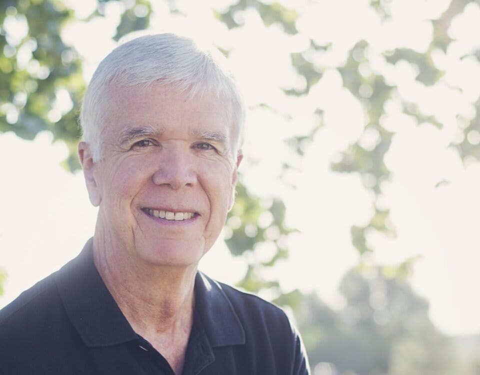 A portrait of Dr. Vernon Redd in a sunny outdoor setting smiling at the camera